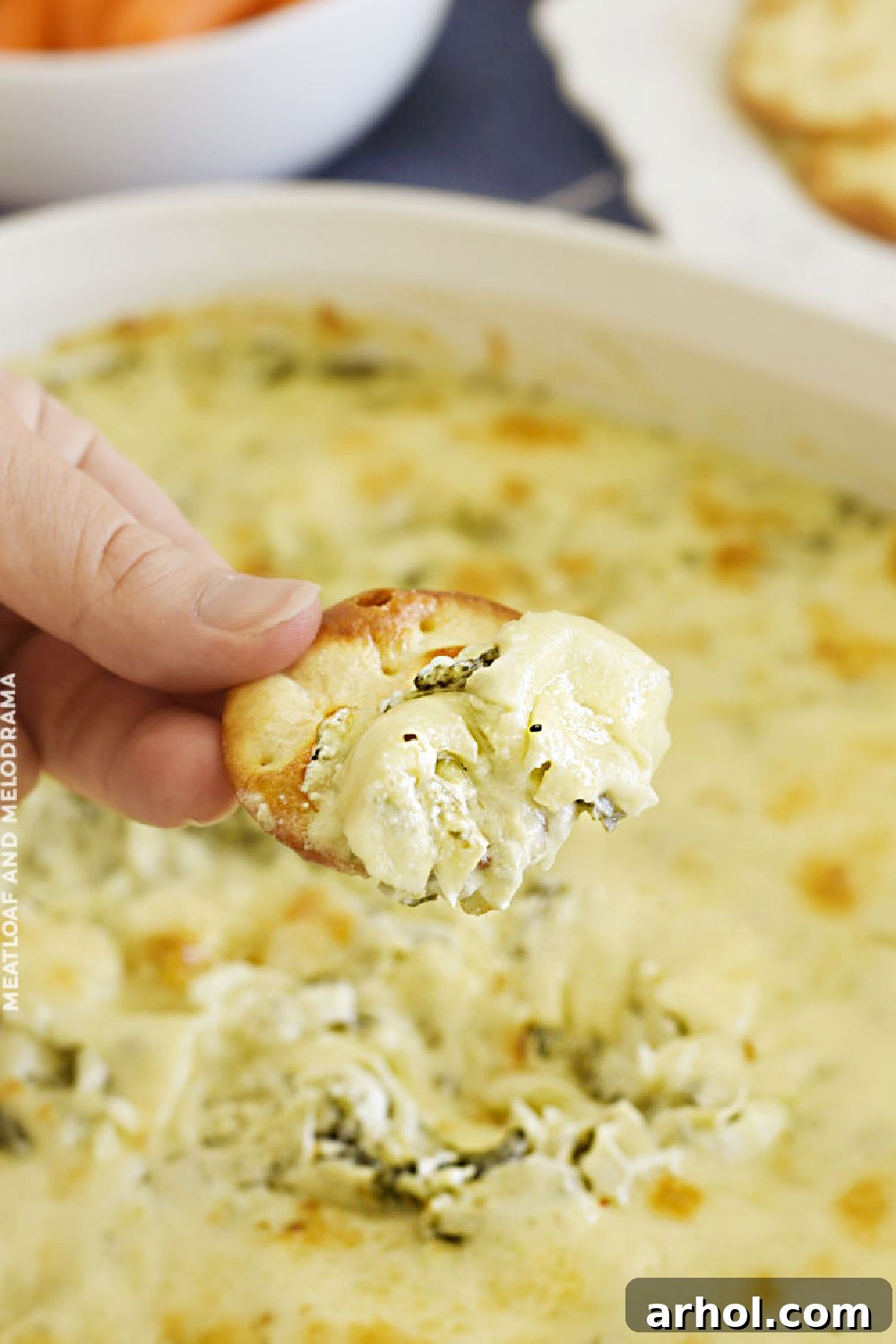 Ultimate Creamy Baked Spinach Artichoke Dip 6 Cracker with a generous scoop of creamy baked spinach artichoke dip.