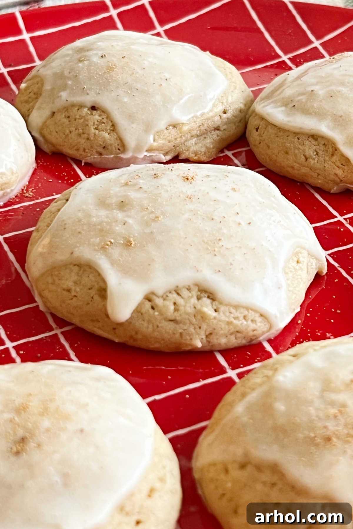 Melt In Your Mouth Glazed Eggnog Cookies 2 A vibrant red plate showcasing several perfectly glazed eggnog cookies, ready for holiday enjoyment.