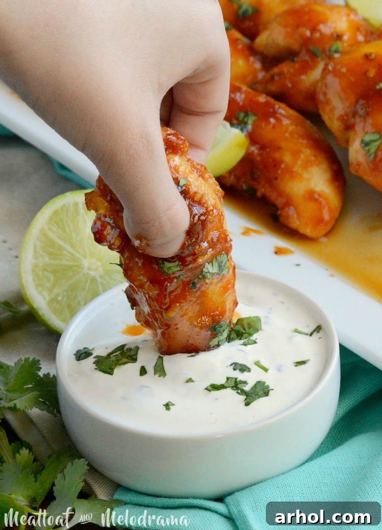 A Baked Honey Chipotle Chicken Tender being dipped into creamy ranch dressing