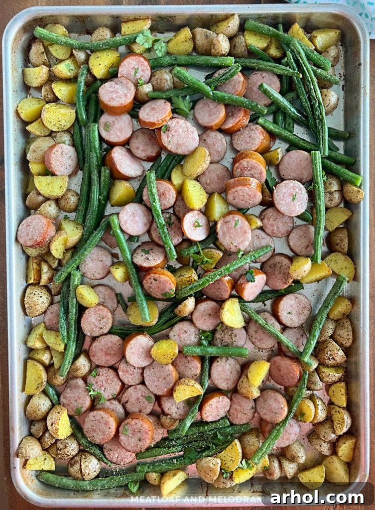 Kielbasa smoked sausage and potatoes baked on a sheet pan, golden brown and ready to serve.