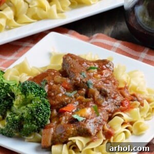 Easy Swiss Steak dinner served over egg noodles with rich tomato-beef gravy.