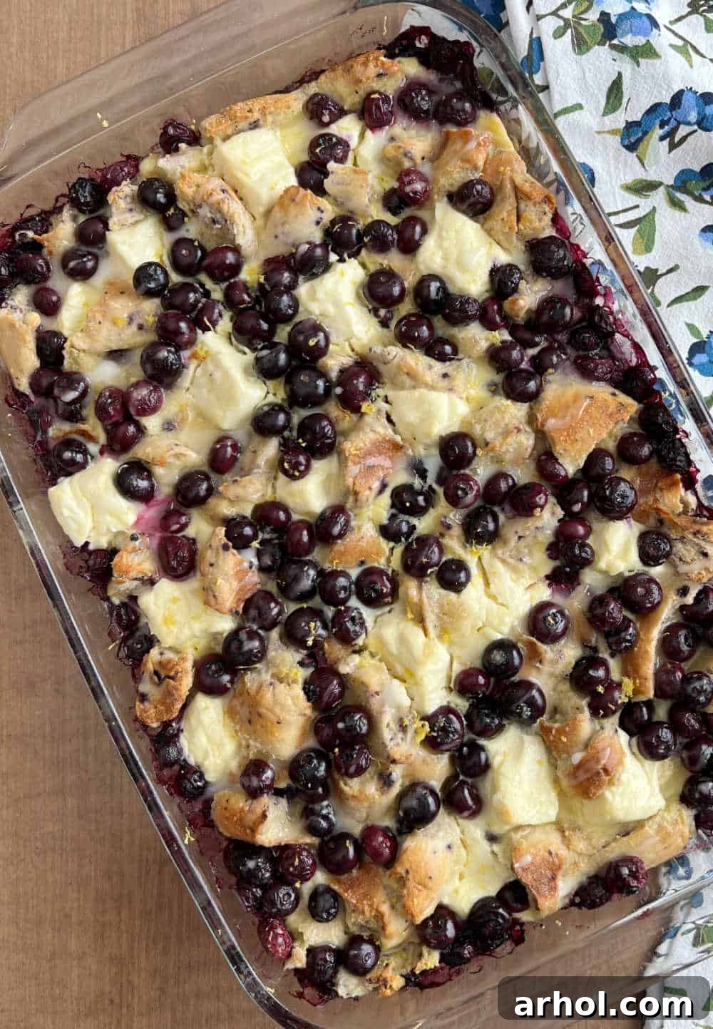 A freshly baked Lemon Blueberry Bagel French Toast Casserole in a ceramic baking dish, golden brown and ready to be served.