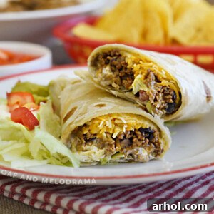 ground beef and black bean burritos with cheese, lettuce and tomatoes on plate