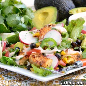 loaded southwest chicken salad with roasted corn and black beans over fresh greens