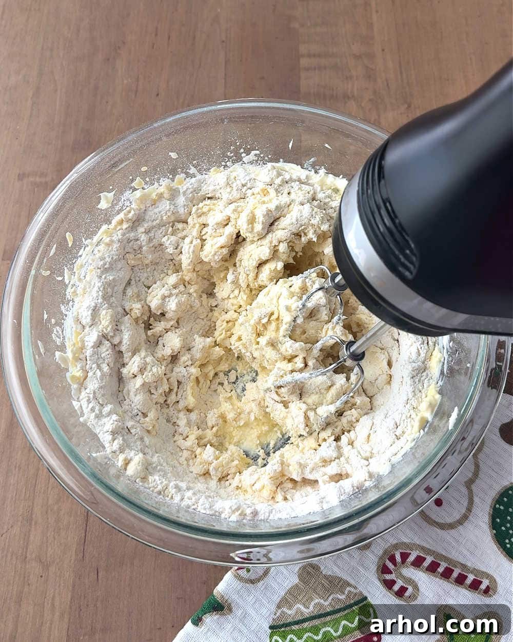 Mixing cookie dough in a bowl, showcasing the integration of wet ingredients.
