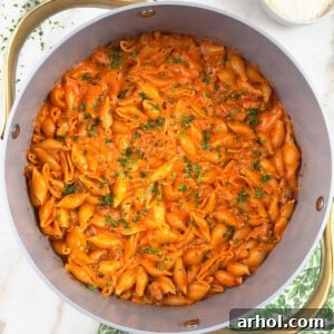 one pot creamy sausage and shells pasta in Dutch oven.