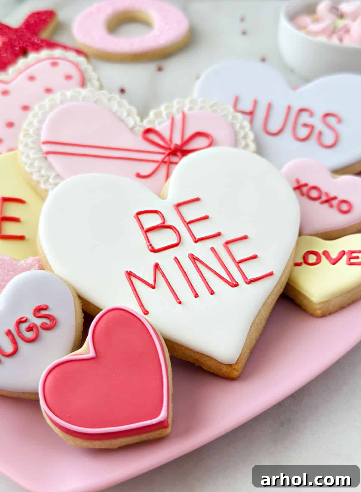 A vibrant plate of decorated sugar cookies for Valentines Day, showcasing various heart designs.