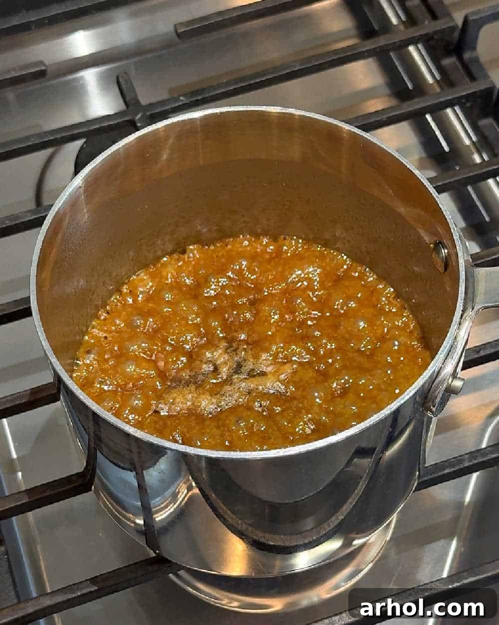 Image showing butter and brown sugar mixture boiling in a saucepan on the stove, forming the caramel toffee.