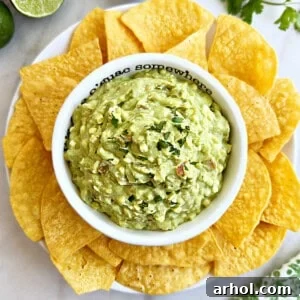 Bowl of avocado cottage cheese dip with tortilla chips on a rustic background.
