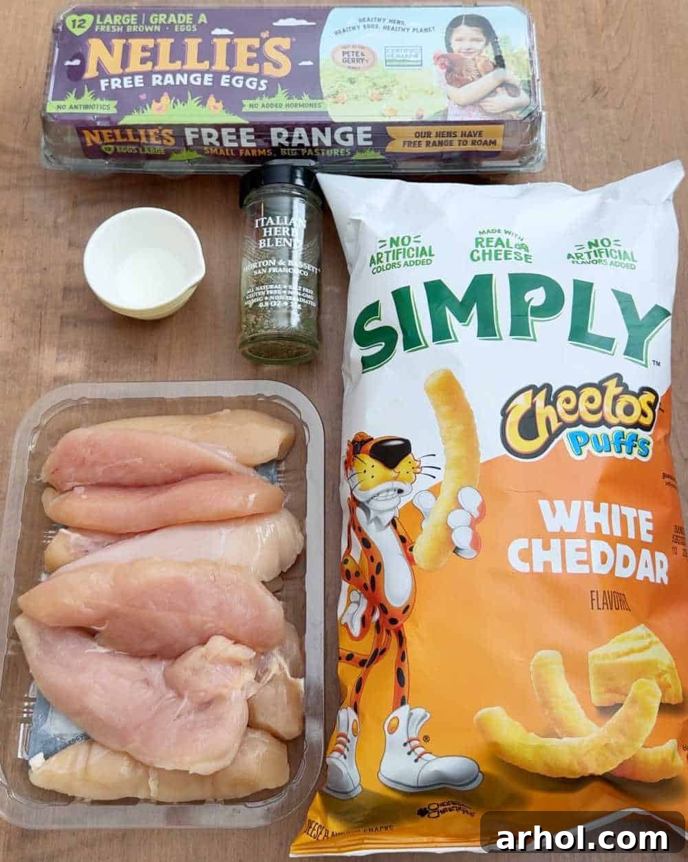 Layout of ingredients for Cheetos chicken: chicken tenders, Simply Cheetos puffs, eggs, milk, Italian seasoning.