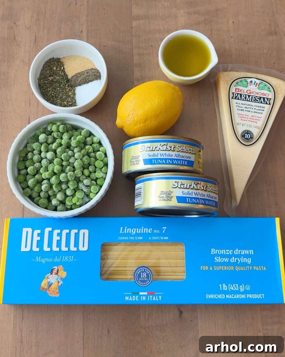 Essential ingredients for tuna pasta: canned tuna, linguine, frozen peas, olive oil, Parmesan, lemon, and spices.