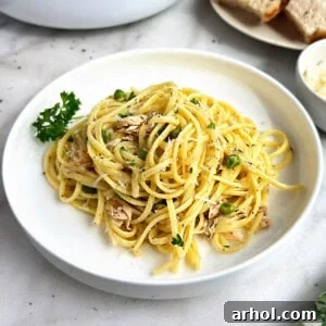 canned tuna pasta with peas, garnished with fresh herbs.