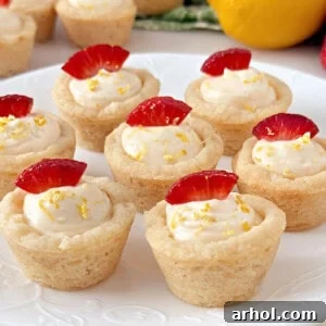 Zesty Lemon Cheesecake Cookie Cups, showcasing a golden sugar cookie crust filled with a creamy, bright lemony cheesecake, ready to be served.
