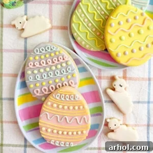 Beautifully decorated Easter cookies shaped like eggs and fluffy lambs, adorned with intricate royal icing designs.
