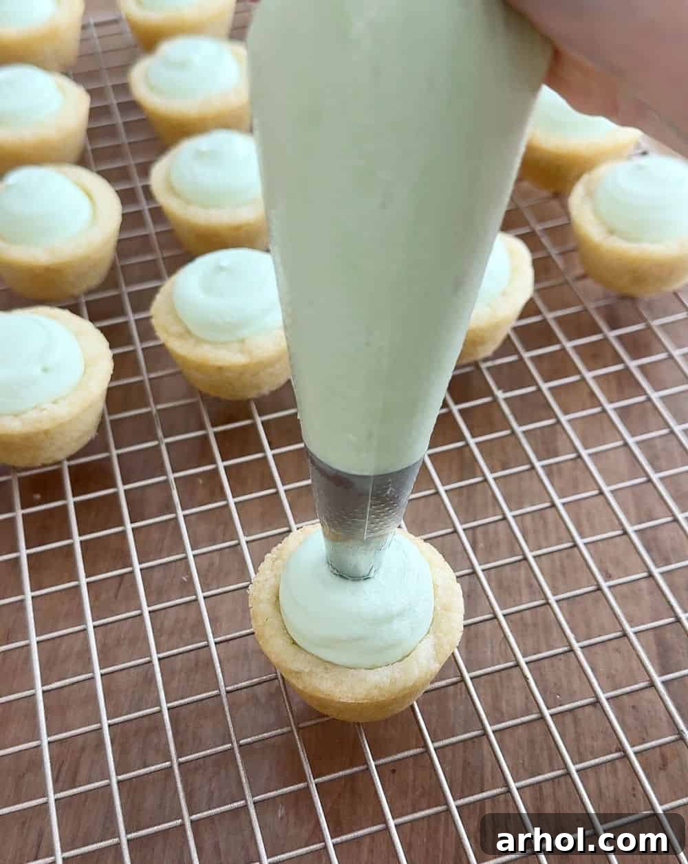 Adorable Easter Cookie Basket Nests 8 Piping green frosting into the shaped sugar cookie cups.