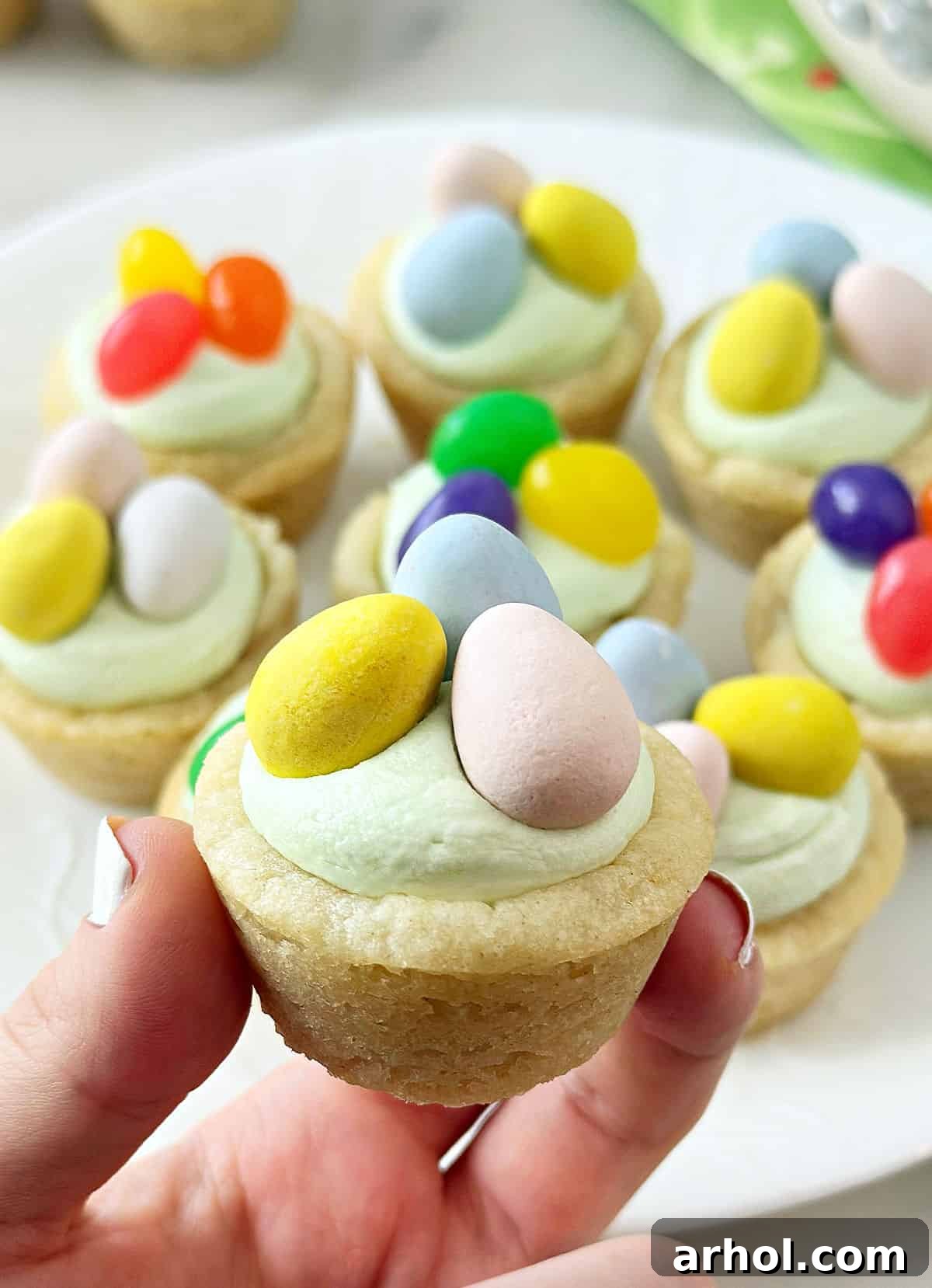 Adorable Easter Cookie Basket Nests 9 A hand holds a perfectly decorated Easter basket sugar cookie cup, showing off its irresistible appeal.