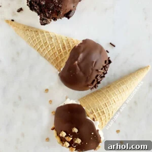Homemade Drumsticks ice cream cones with chocolate coating on a marble surface.