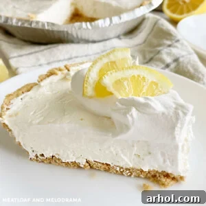 No-bake lemonade Kool-Aid pie with a lemon slice and graham cracker crust on a white plate.