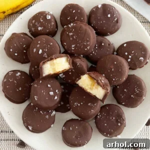 Frozen chocolate banana bites with flaked sea salt on a plate, a healthy summer treat.
