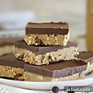Stacked no-bake chocolate peanut butter bars on a white plate.