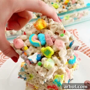 Lucky Charms marshmallow treats held in hand, a festive and sweet snack.