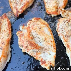 Perfectly grilled chicken breasts with char marks on a Blackstone griddle.