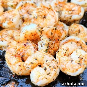 Succulent cooked shrimp on a Blackstone griddle, glistening with flavor.