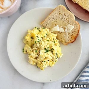 Creamy scrambled eggs with cream cheese and chives on a plate