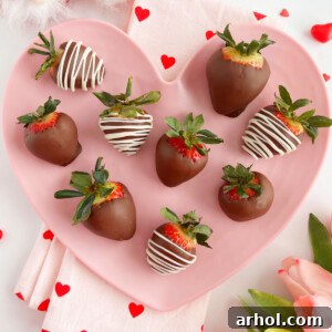 Chocolate-covered strawberries with a white chocolate drizzle on a plate
