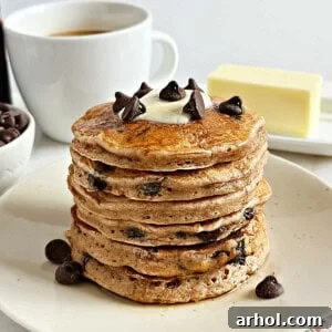 A stack of chocolate chip pancakes with a pat of butter