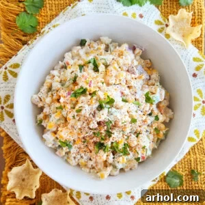 Mexican street corn salad (elote salad) topped with cotija cheese and cilantro in a white serving bowl