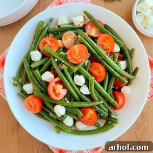 green bean and tomato salad with mozzarella pearls in a bowl.