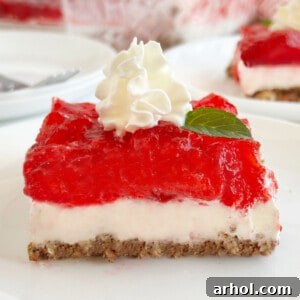 slice of strawberry pretzel salad with whipped cream on a plate.
