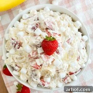 strawberry banana cheesecake salad in white bowl with marshmallows
