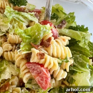 blt pasta salad with rotini pasta and bacon and lettuce and tomatoes on a spoon