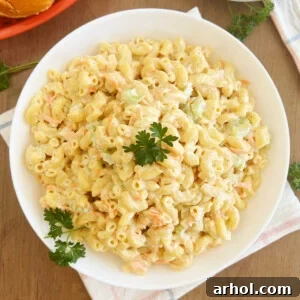 Hawaiian macaroni salad with carrots and celery and parsley in white bowl