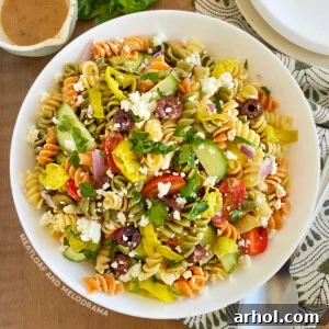 Greek pasta salad with feta cheese in white serving bowl