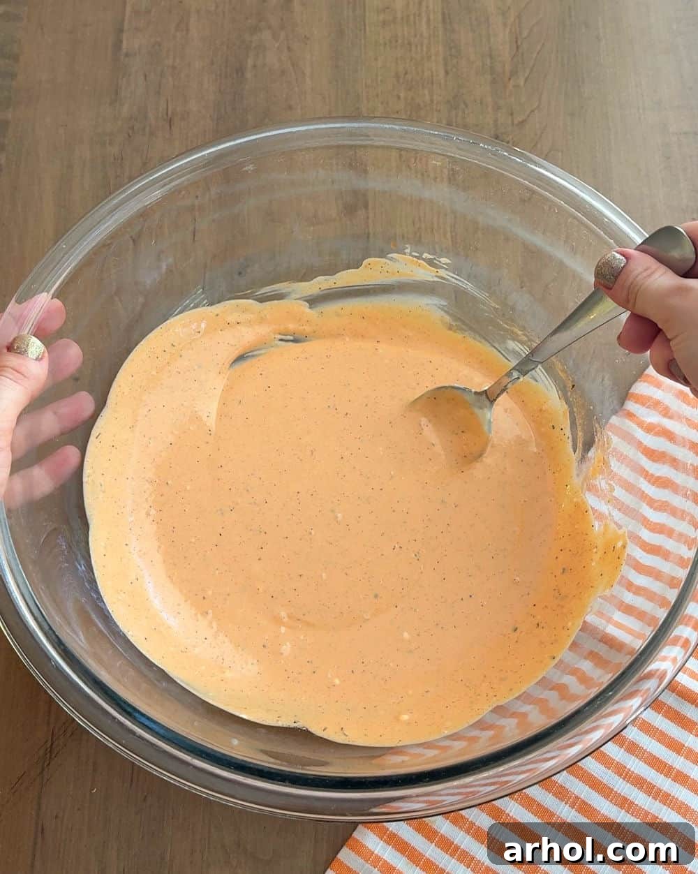 mixing dressing in glass bowl.