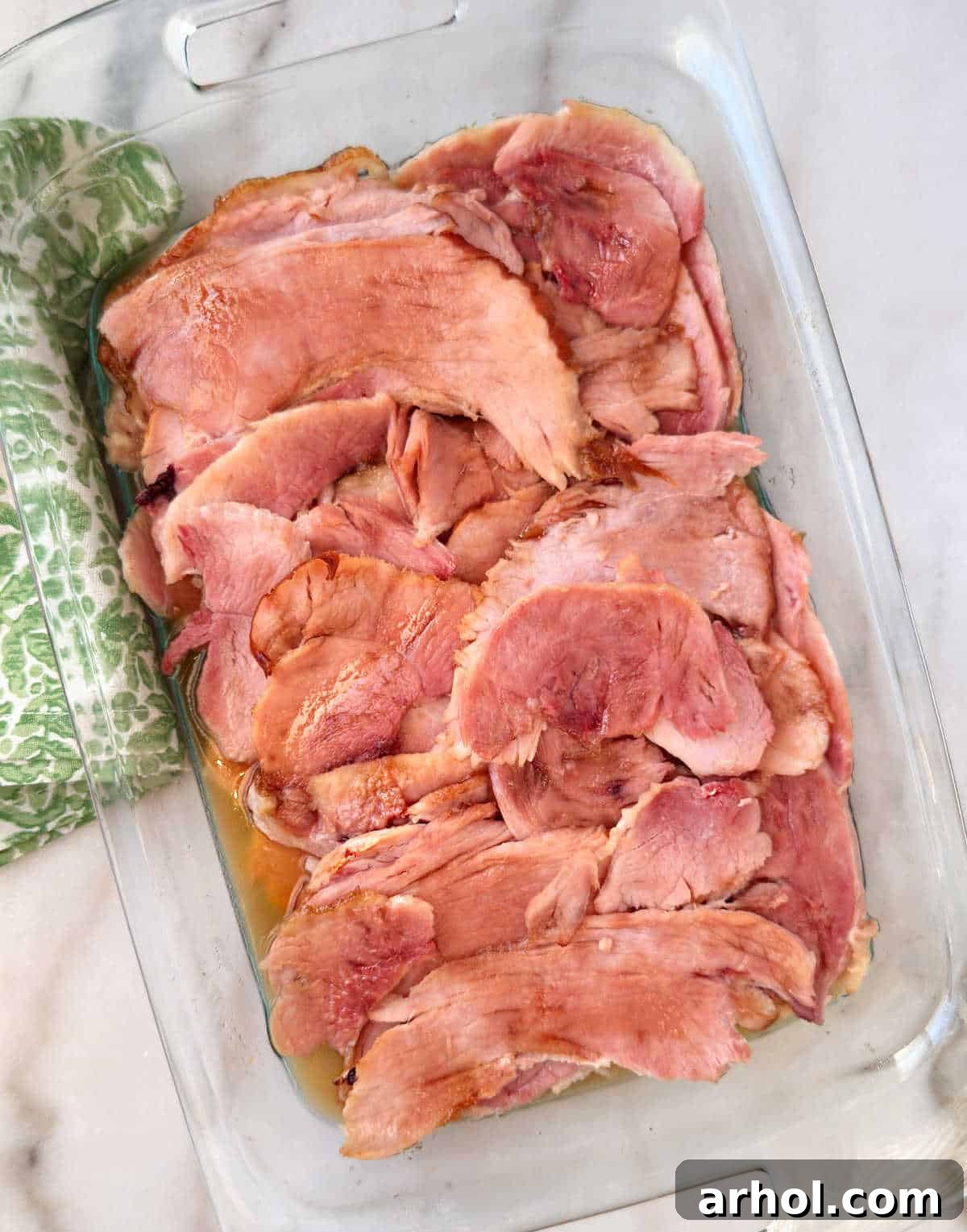 Perfect Oven-Baked Ham Slices: Easy, Juicy Recipe for Weeknight Dinners 2 baked ham slices with brown sugar in baking dish.