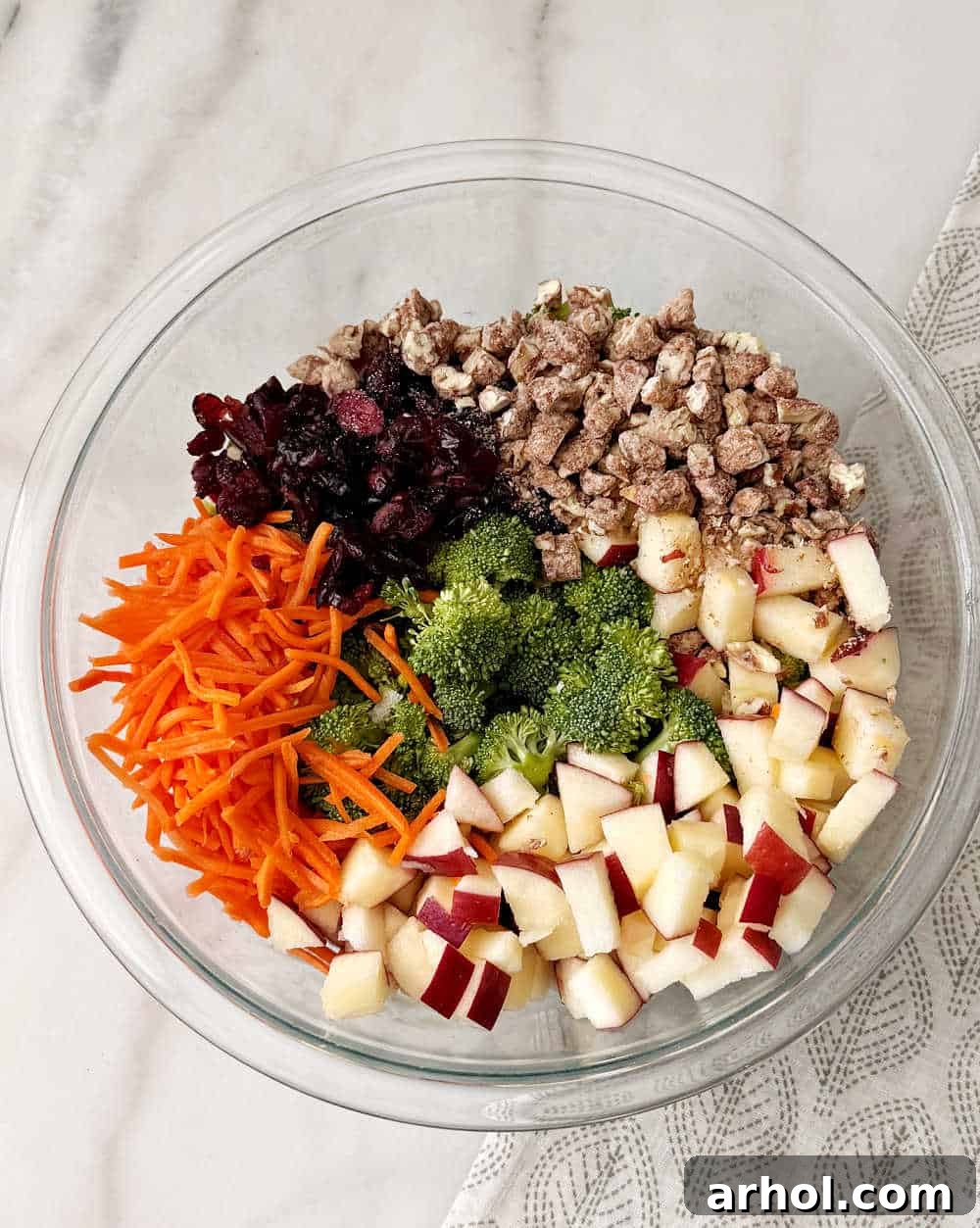 adding salad ingredients to large bowl.