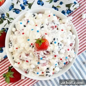 red white and blue cheesecake salad with marshmallows and strawberry on top