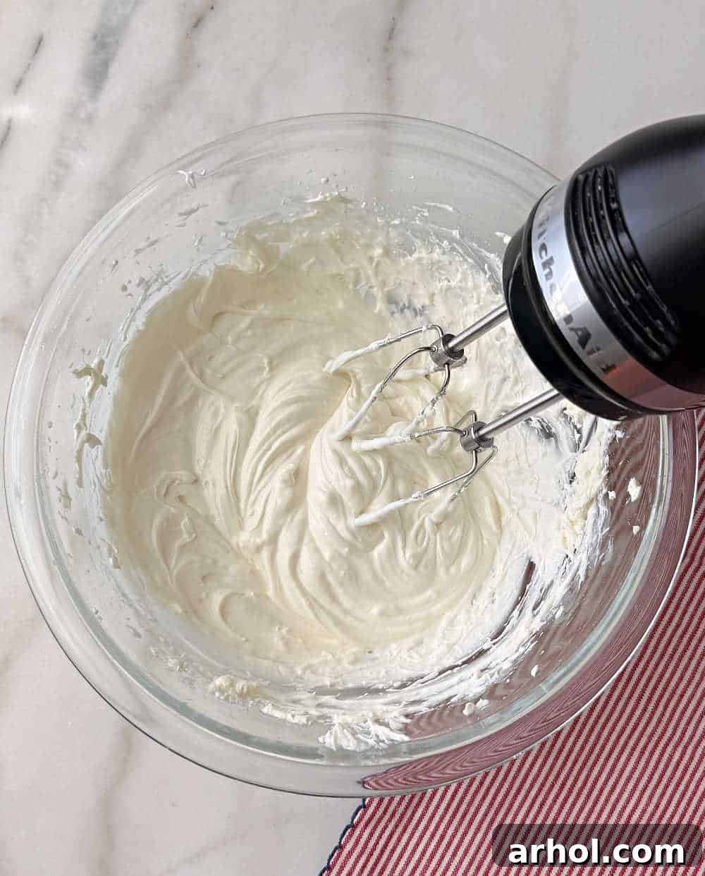 Patriotic Red, White & Blue Cheesecake Dip Recipe for Parties 6 mixing cheesecake filling in glass bowl.