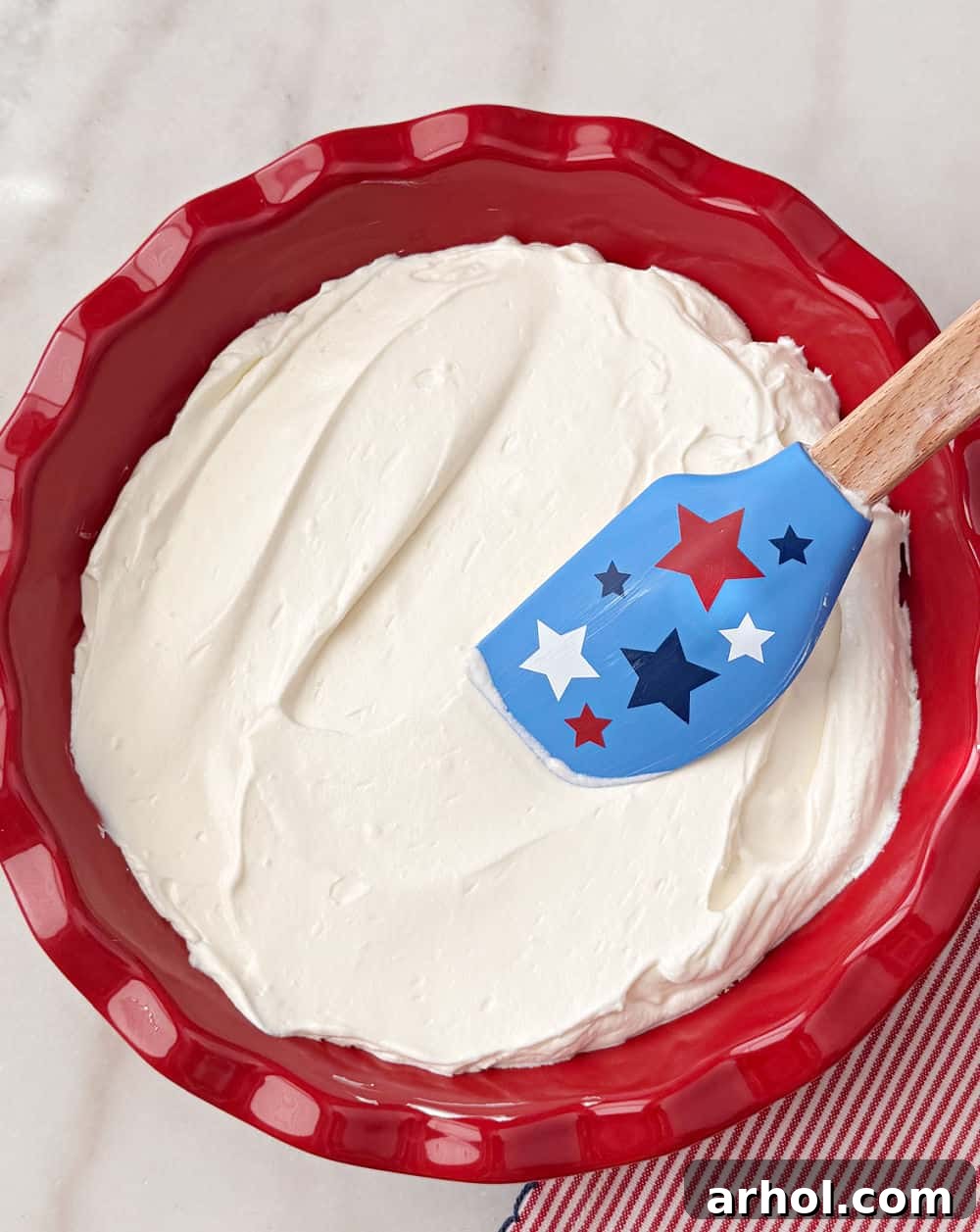 Patriotic Red, White & Blue Cheesecake Dip Recipe for Parties 7 spreading creamy base in pie dish with star spatula.