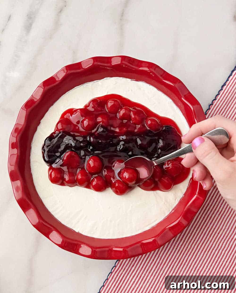 Patriotic Red, White & Blue Cheesecake Dip Recipe for Parties 8 spooning pie filling on top.