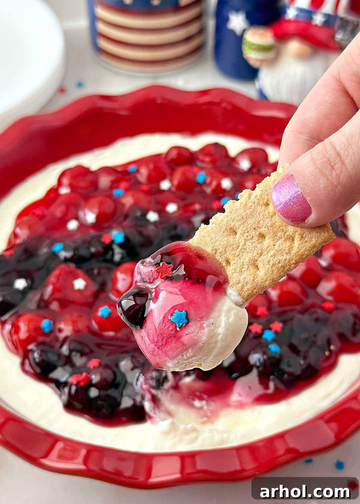 Patriotic Red, White & Blue Cheesecake Dip Recipe for Parties 9 red, white and blue cheesecake dip on graham cracker.