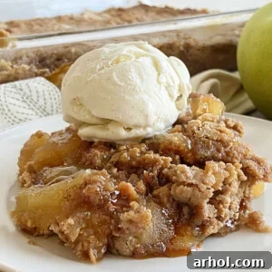 apple pie dump cake with scoop of vanilla ice cream and caramel sauce on a plate