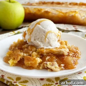 caramel apple dump cake with scoop of vanilla ice cream and caramel sauce on plate.