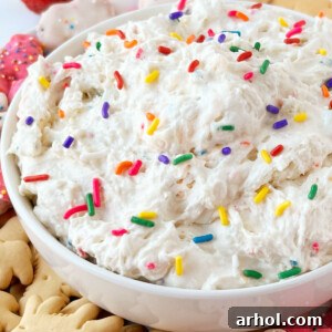 dunkaroo dip (funfetti cake batter dip) in a serving bowl with animal crackers and rainbow sprinkles on top