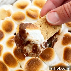 easy smores dip with melted chocolate and gooey marshmallows on a graham cracker