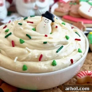 Christmas sugar cookie dip with snowman cookie in white bowl.
